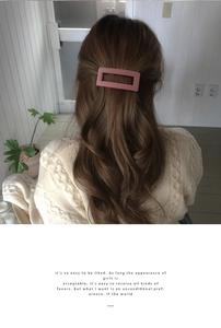 Close-up of matte pink rectangular hair clip worn on the back of a woman's head
