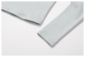 Detailed close-up showing precision double-needle stitching on light blue yoga top hem