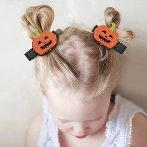 Cute Halloween pumpkin hair clips with orange sequins on a little girl's double buns