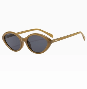 Detail of vintage cat-eye sunglasses featuring silver rivet accents on amber acetate frame