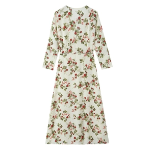 Detail of vintage floral maxi dress with red rose patterns and waist tie on beige fabric
