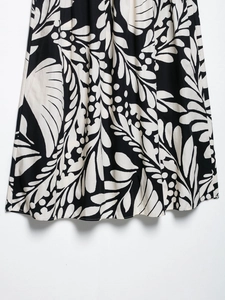 Gros plan sur l'imprimé floral noir et blanc d'une jupe midi montrant le détail du tissu