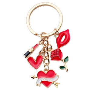 Golden keychain with red lips, rose, lipstick and love heart charms on white background
