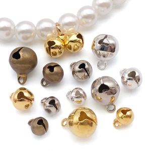 Close-up of colorful DIY alloy bell pendants in gold and silver for jewelry making