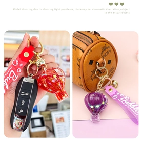 Detailed view of hot air balloon keychain with quicksand glitter and silicone strap