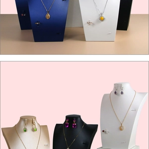 Macro detail of various jewelry bust stands and flat necklace display organizers in velvet