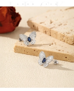 Détail de boucles d'oreilles papillon en argent S925 avec pierre bleue et zircon serti