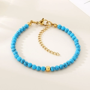 Détail des perles en marbre bleu et du fermoir en acier inoxydable doré sur le bracelet