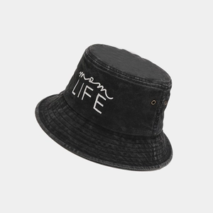 Detailed macro view of white mom LIFE embroidery on black washed denim bucket hat