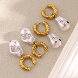 Close-up of 18K gold-plated hammered hoop earrings with baroque pearls and gems