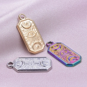 Macro shot of rectangular stainless steel evil eye charms in gold silver and rainbow finishes