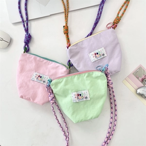 Detailed top view of pastel canvas mini crossbody bags with colorful woven rope straps