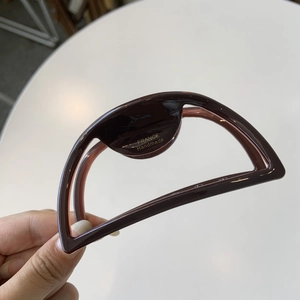 Detail of dark mahogany hair claw clip featuring golden FRANCE Handmade logo engraving