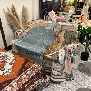 Close-up of bohemian woven camping blanket featuring retro jacquard pattern and fringe edge