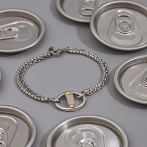 Detail showing high-polish stainless steel Cuban chain with gold rivets and box link layers