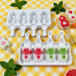 Silicone heart shaped ice cream mold with 4 cavities and wooden sticks on a table