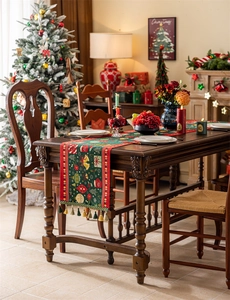 Detail of green Christmas table runner with festive patterns and decorative tassels