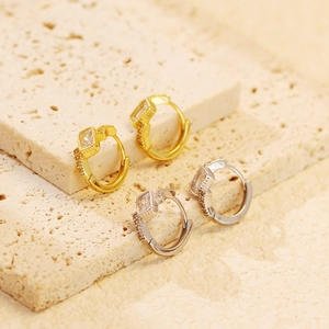 Close-up of geometric rectangular crystal hoop earrings in gold and silver finish
