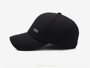 Detail of black baseball cap featuring textured herringbone fabric and metal logo plaque