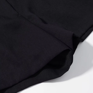 Detailed macro view of black twill fabric texture and pocket stitching on casual shorts