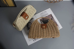 Detail of cream and brown woven straw handbags with leather buckles and metal locks