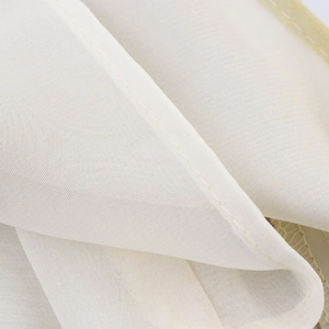 Macro du tissu blanc semi-transparent avec coutures fines et finitions de bords précises