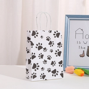 Detail of cartoon paw print gift bag with white twisted paper handles on a table