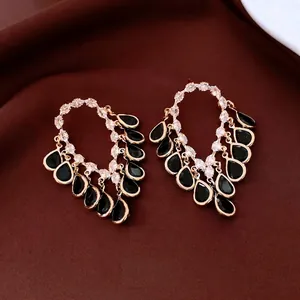 18K gold plated silver needle tassel earrings with black teardrop gemstones on brown fabric