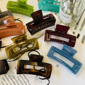 Detail of colorful rectangular hollow hair claws with premium glossy finish and gold springs