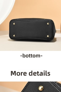 Detailed base view of black pebbled leather handbag with gold-tone protective metal feet