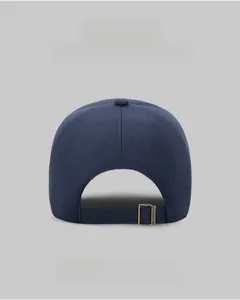 Detail of navy twill baseball cap back showing adjustable strap and bronze metal buckle