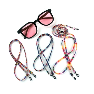 Close-up of bohemian woven eyeglass cords in vibrant ethnic patterns with silicone loops