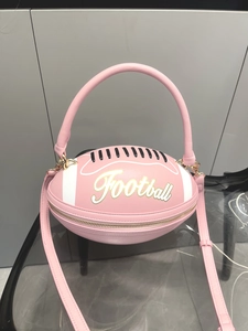 Detail of pink football-shaped handbag featuring litchi texture and golden hardware