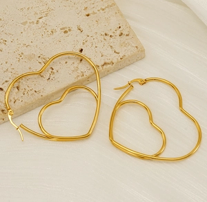 Gros plan de boucles d'oreilles créoles doubles cœurs plaquées or 18 carats sur pierre