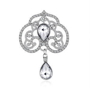 Close-up of silver brooch with clear marquise gems and intricate filigree details