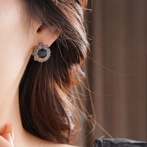 Close-up of elegant flower shaped earrings with black gemstones and sparkling crystals