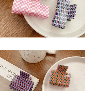 Detailed view of four checkerboard pattern hair claw clips in various pastel colorways