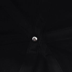 Detailed macro view of internal stitching and metal rivet on black cotton baseball cap