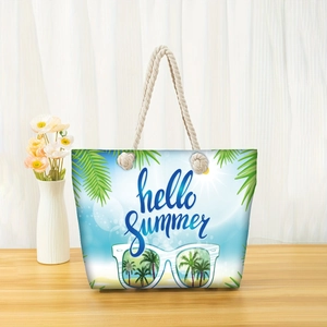 Detail of hello summer canvas tote bag with white rope handles on a wooden table