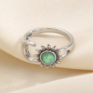 Vintage sun and moon open ring with green faux opal stone on beige fabric background