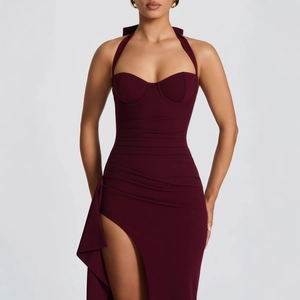 Detail of burgundy ruched maxi dress featuring a high slit and elegant side ruffles