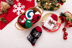 Detailaufnahme festlicher Korallenvlies-Socken mit Rentier- und Schneeflockenmustern