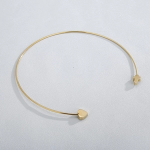 Detailed top view of gold heart and cross charms on a 2mm titanium steel choker necklace
