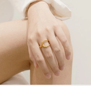 Minimalist gold irregular flower ring on model hand with a textured hand-crafted aesthetic