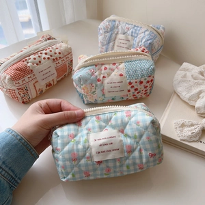 Detailed close-up of quilted floral cotton cosmetic bags with premium zipper closure