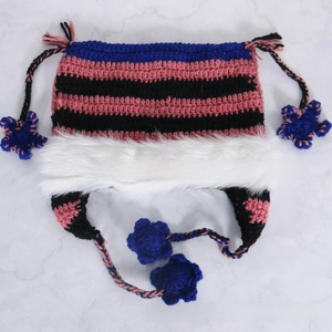 Detailed macro view of colorful striped knit cat ear hat with faux fur trim and flowers