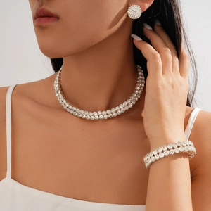Close-up of elegant double-row rhinestone necklace, bracelet, and earrings set on model