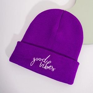 Detailed view of the purple beanie featuring white good vibes embroidery text