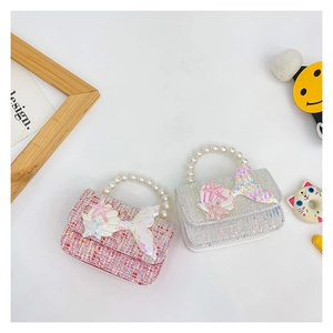 Detailed view of pink tweed and white sequin girls' handbags with pearl handles