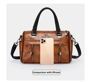 Detail of vintage brown leather handbag with gold kangaroo logo and zipper pockets
